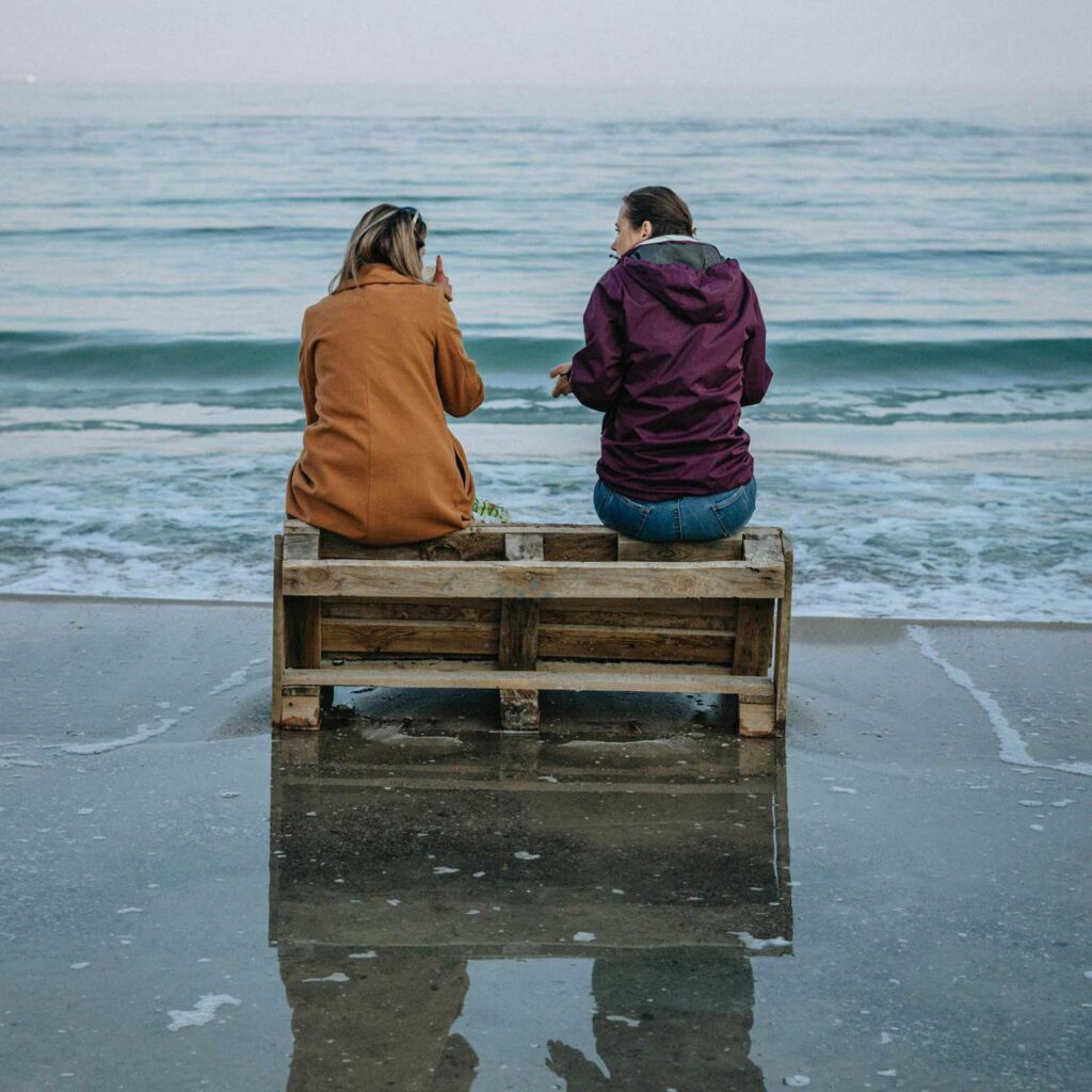 two women talking on a beach